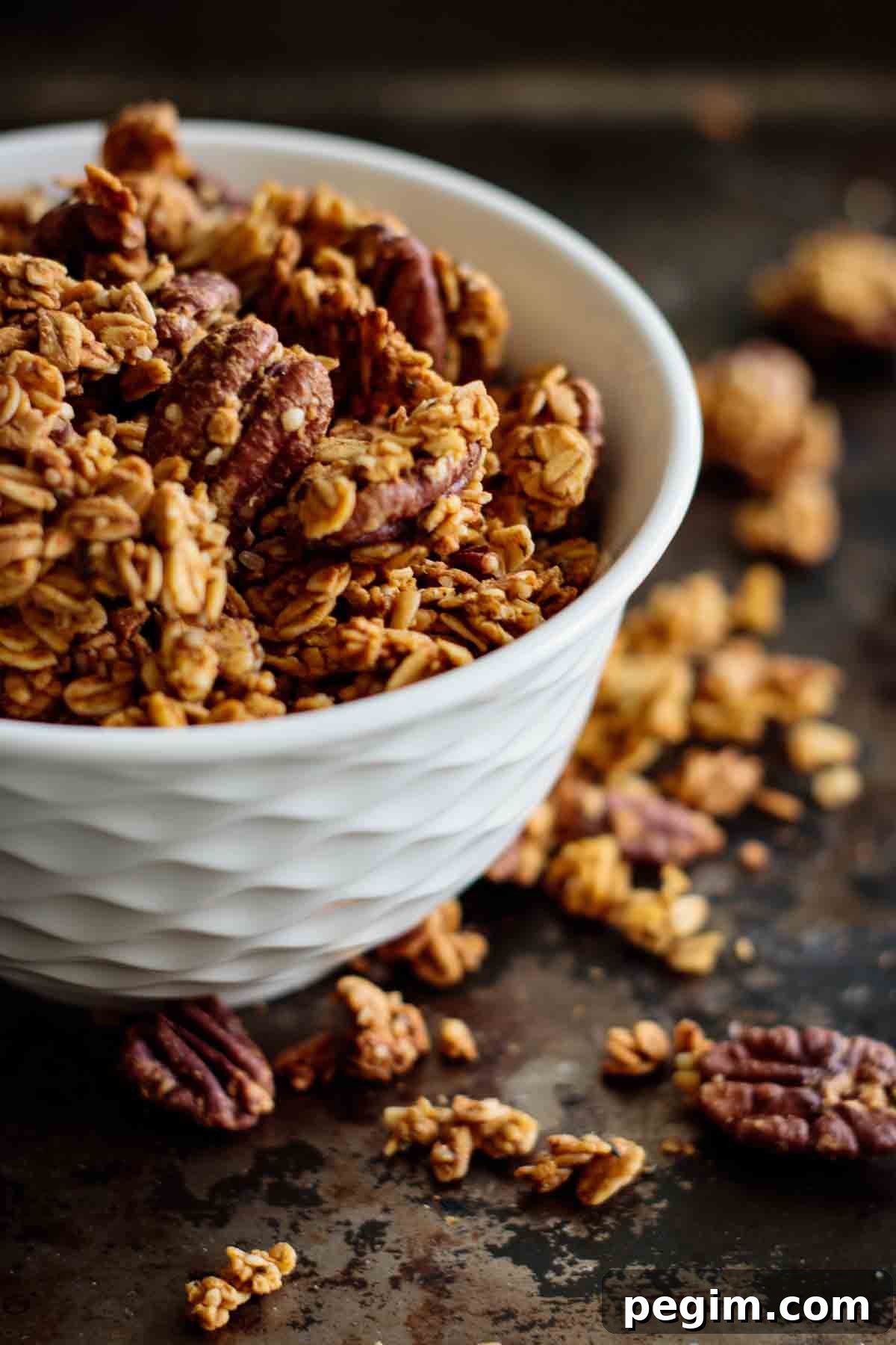 Pumpkin spice granola inside a white bowl.