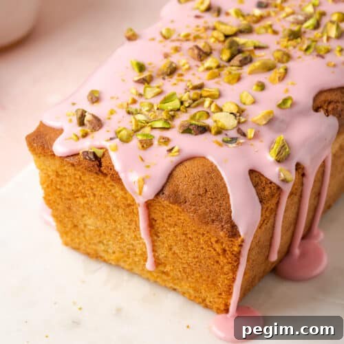 Blood orange pound cake topped with pink icing and chopped pistachios.