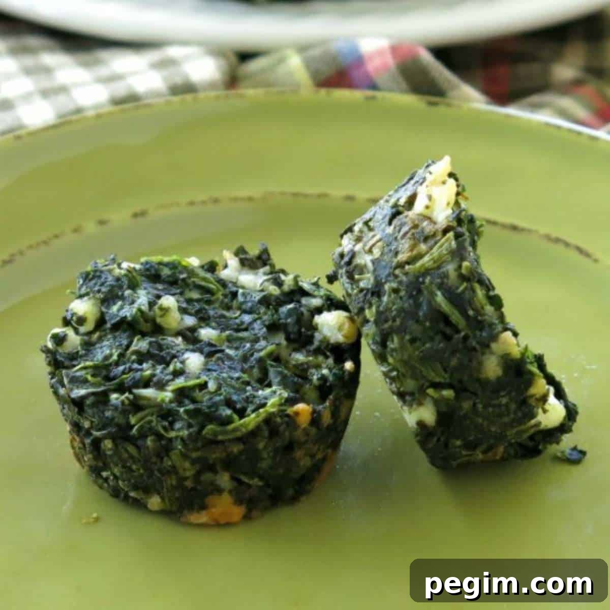 2 spinach egg muffins with feta cheese on a green plate.