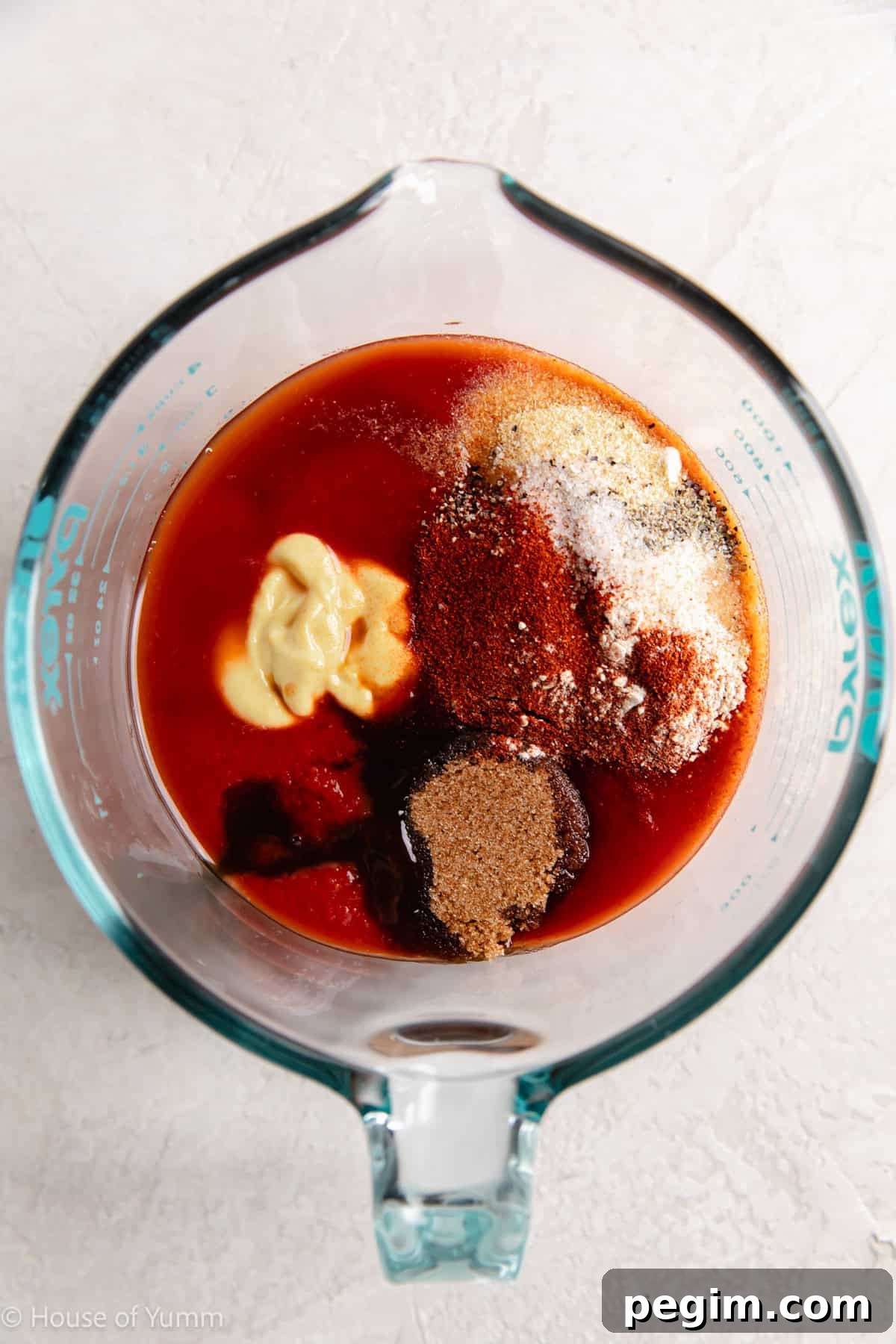 Tomato sauce and other ingredients needed to make a homemade bbq sauce in a large measuring cup.