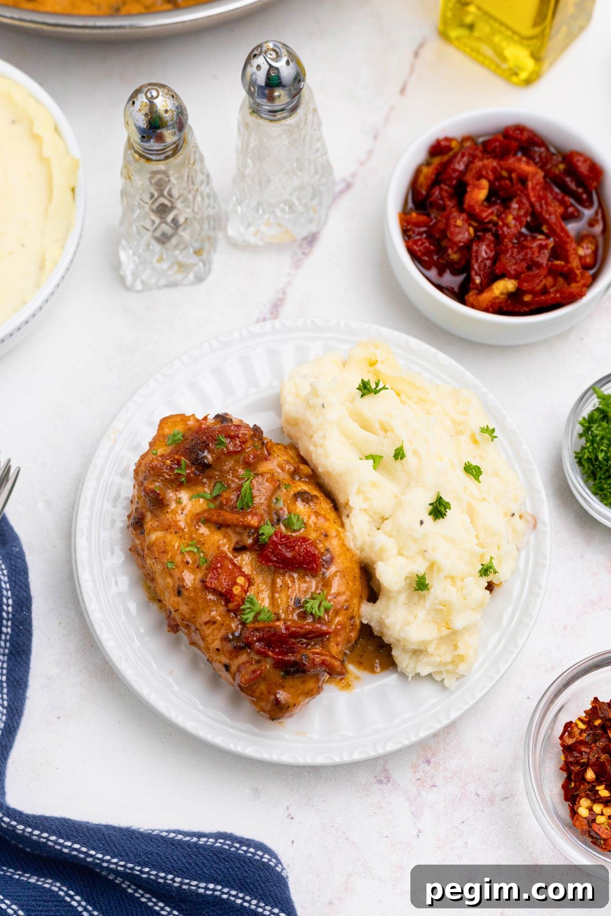 Golden, juicy chicken breast on a white plate with mashed potatoes. 