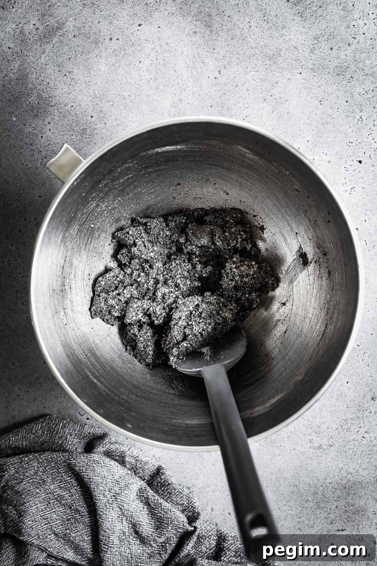A mixing bowl with butter, sugar and ground black sesame seeds mixed together.