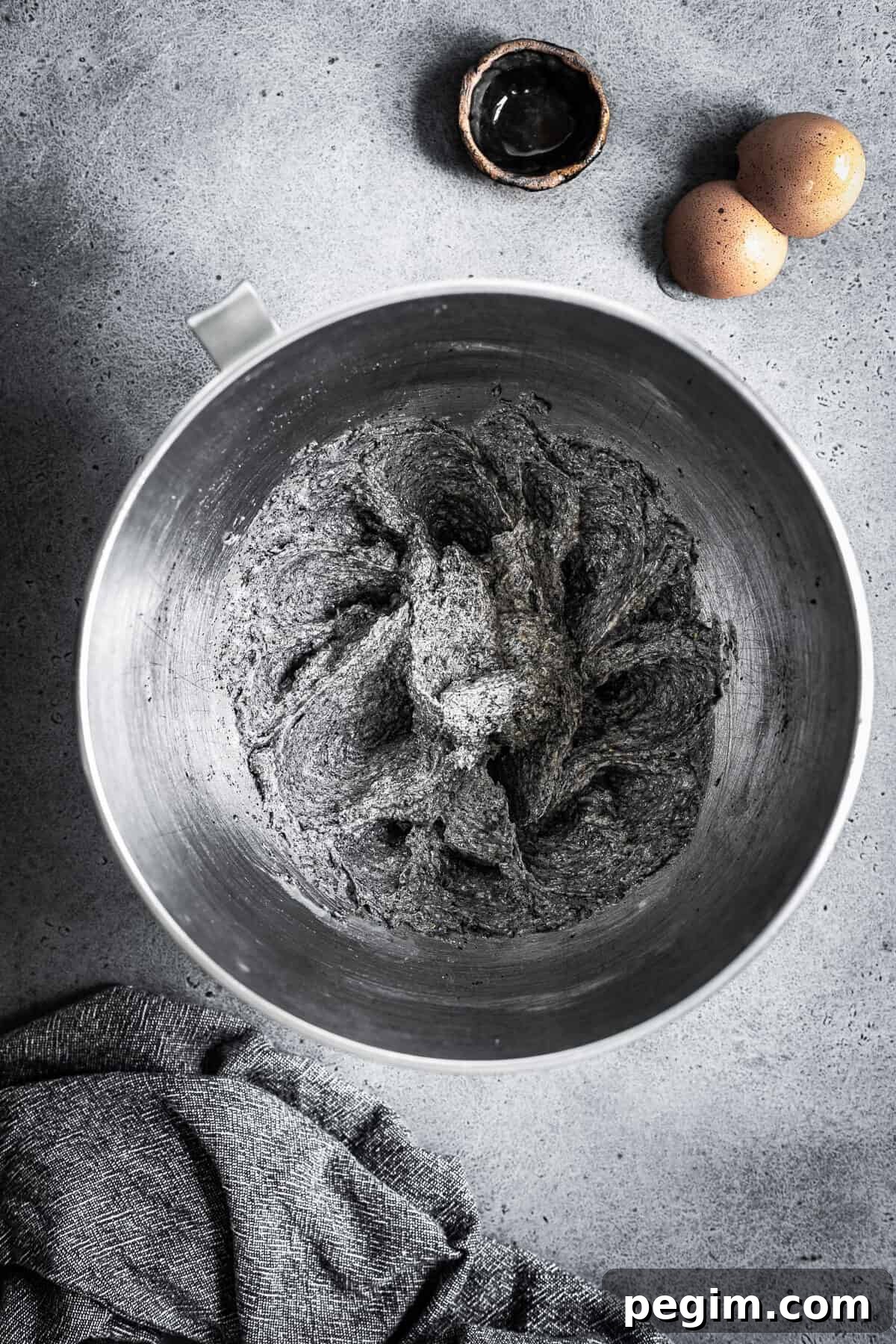 A mixing bowl with butter, sugar, eggs and vanilla mixed together.