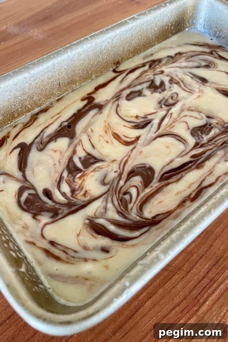 batter in a loaf pan with swirls of nutella throughout. 