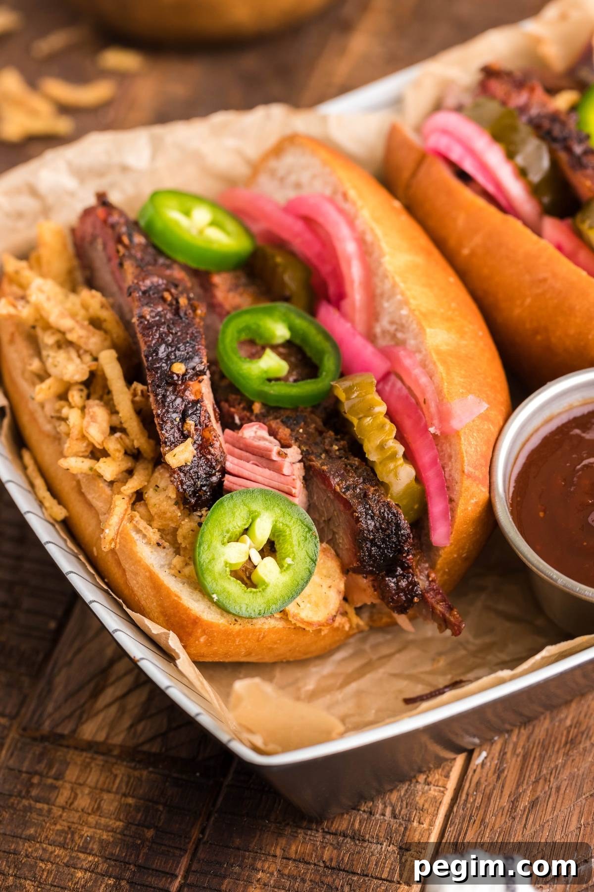 Brisket sandwich using leftover brisket topped with fried onions, pickles, jalapeños and pickled red onions.