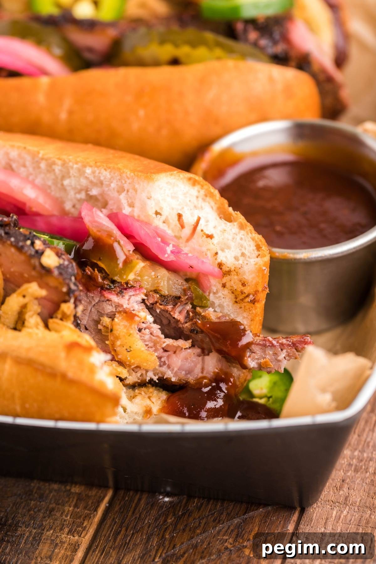 Smoked brisket sandwich with pickled onions and classic toppings served with barbecue sauce.