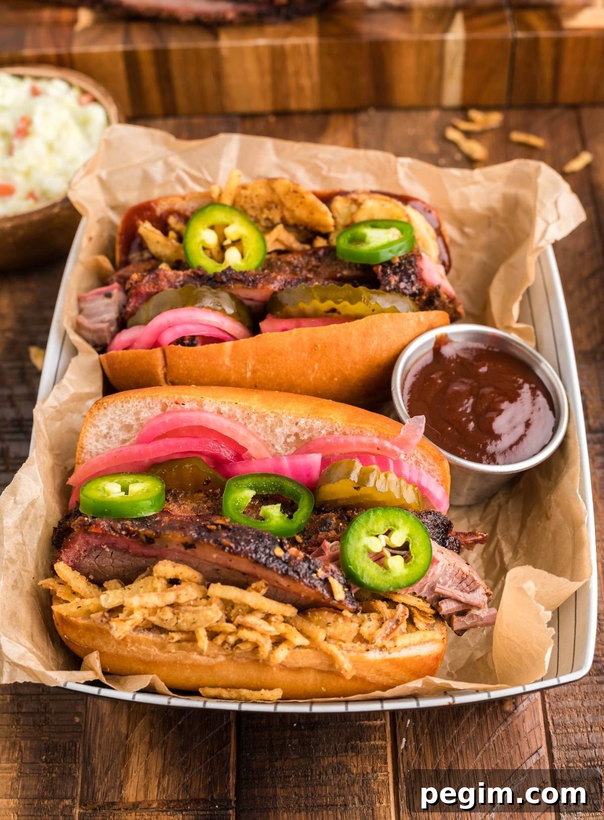 Enjoy the best BBQ brisket sandwich with pickles, jalapeños and onions served with barbecue sauce.