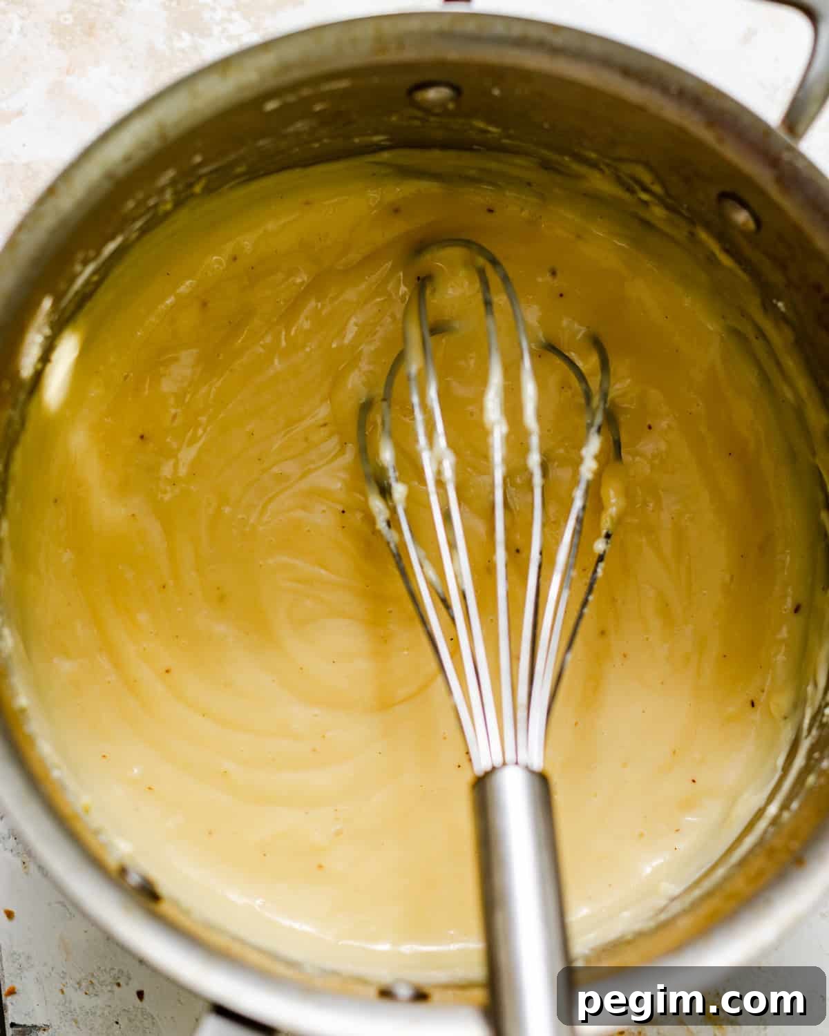 vanilla bean pastry cream in a saucepan with a whisk.