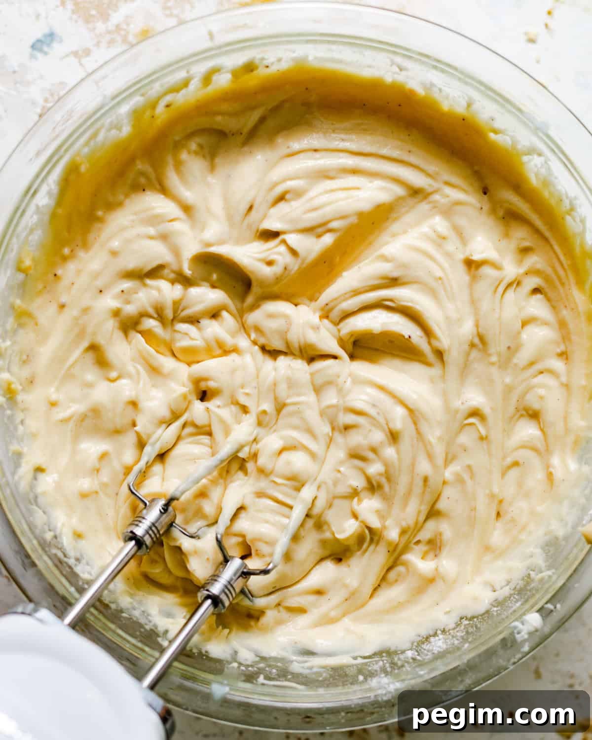 mascarpone pastry cream mixed together in a bowl with a hand mixer.