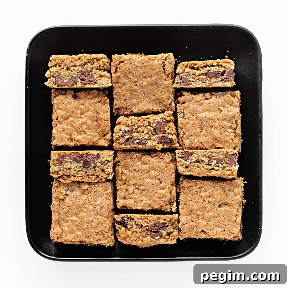 Cut squares of Chocolate Chip Oatmeal Bars on a square serving plate.