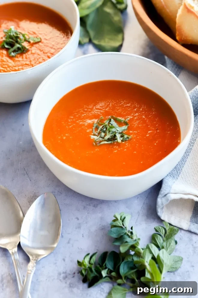 Side photo of bowls of soup with spoons and bread