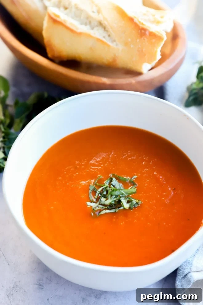 Bowl of tomato soup with basil and bread image