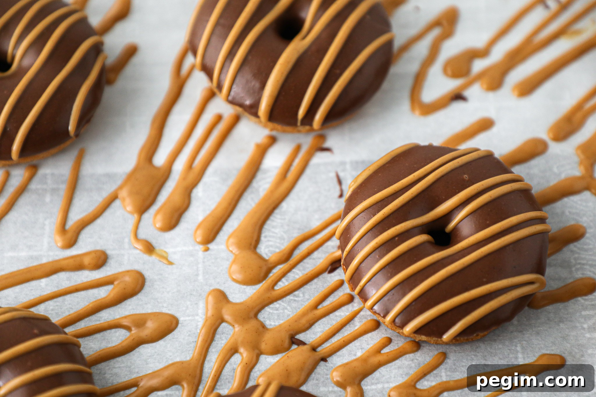 Easy banana donuts that are made with simple ingredients and drizzled with chocolate peanut butter and regular peanut butter.