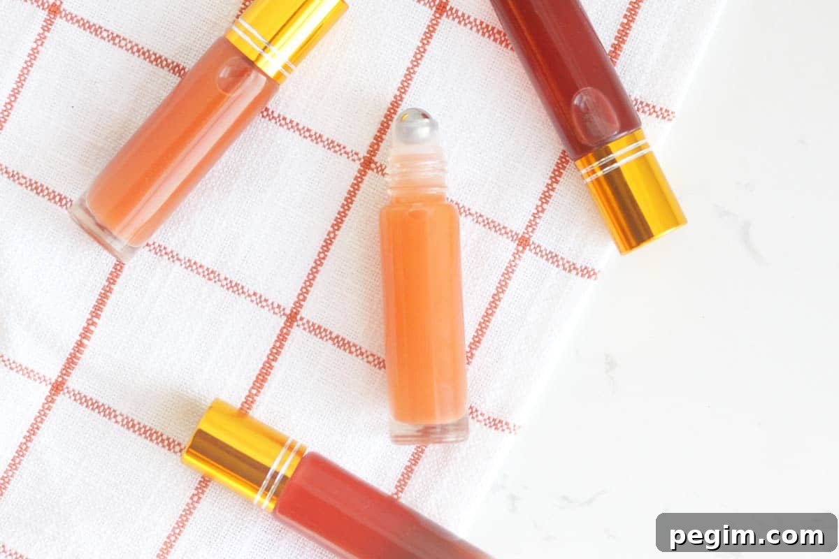 a pink lip gloss in a roller ball bottle with several bottles in the background