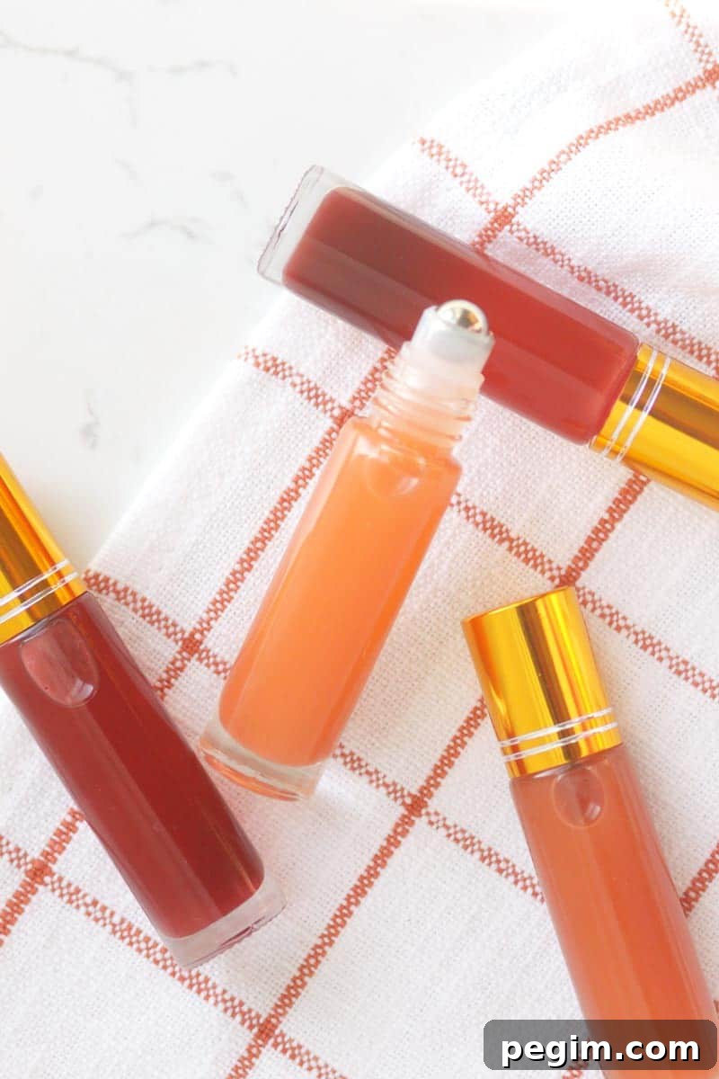 a pink lip gloss in a roller ball bottle with several bottles in the background