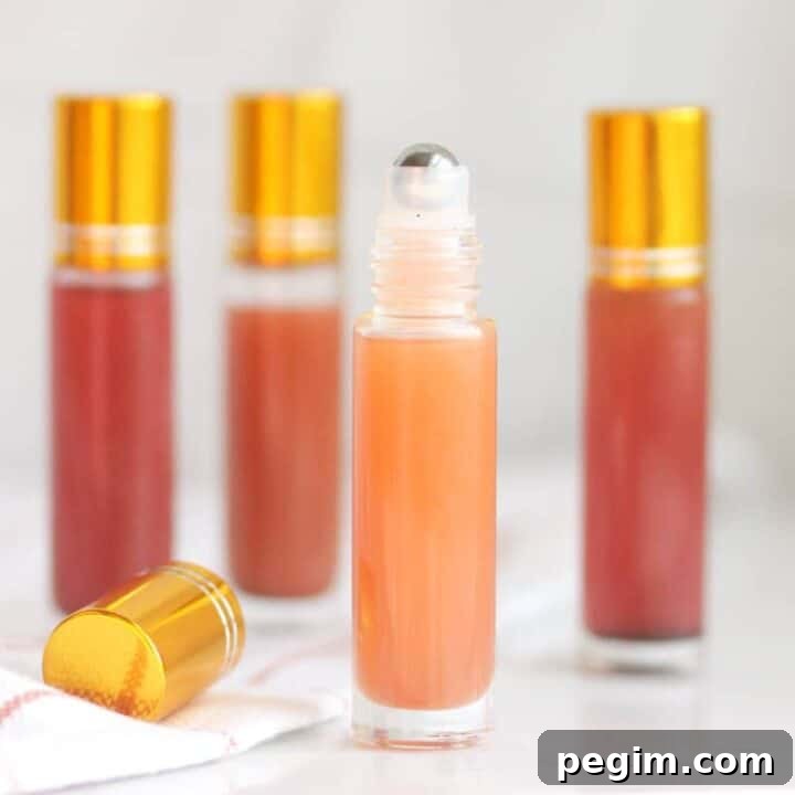 a pink lip gloss in a roller ball bottle with several bottles in the background