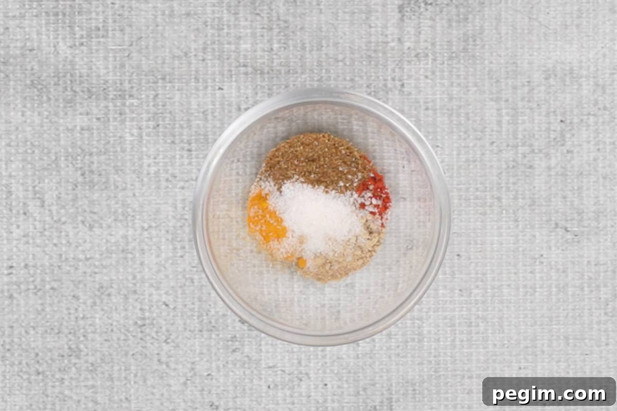 Spice powders added to a bowl.