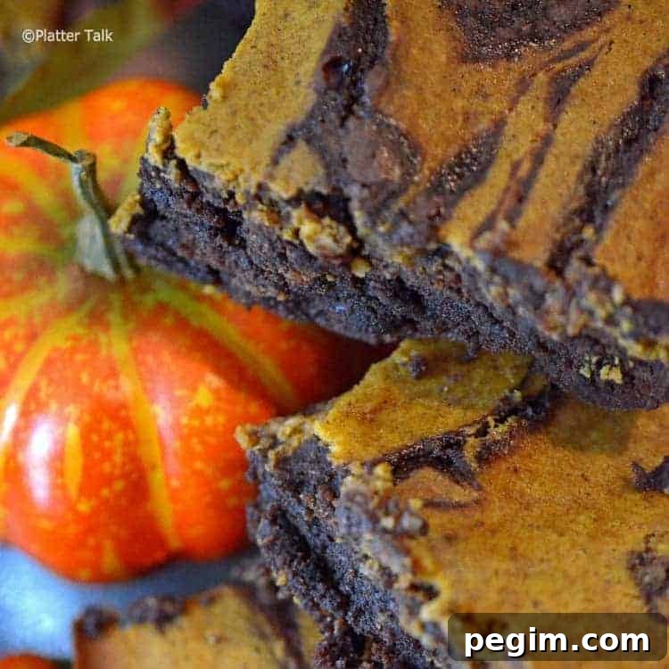 Pumpkin Cheesecake Brownies Recipe — Gooey Fall Dessert 4 a close up of pumpkin cheesecake brownies.