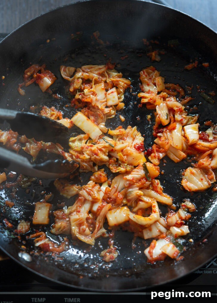 Chopped kimchi cooking in olive oil to make Mediterranean-Korean fusion pasta.
