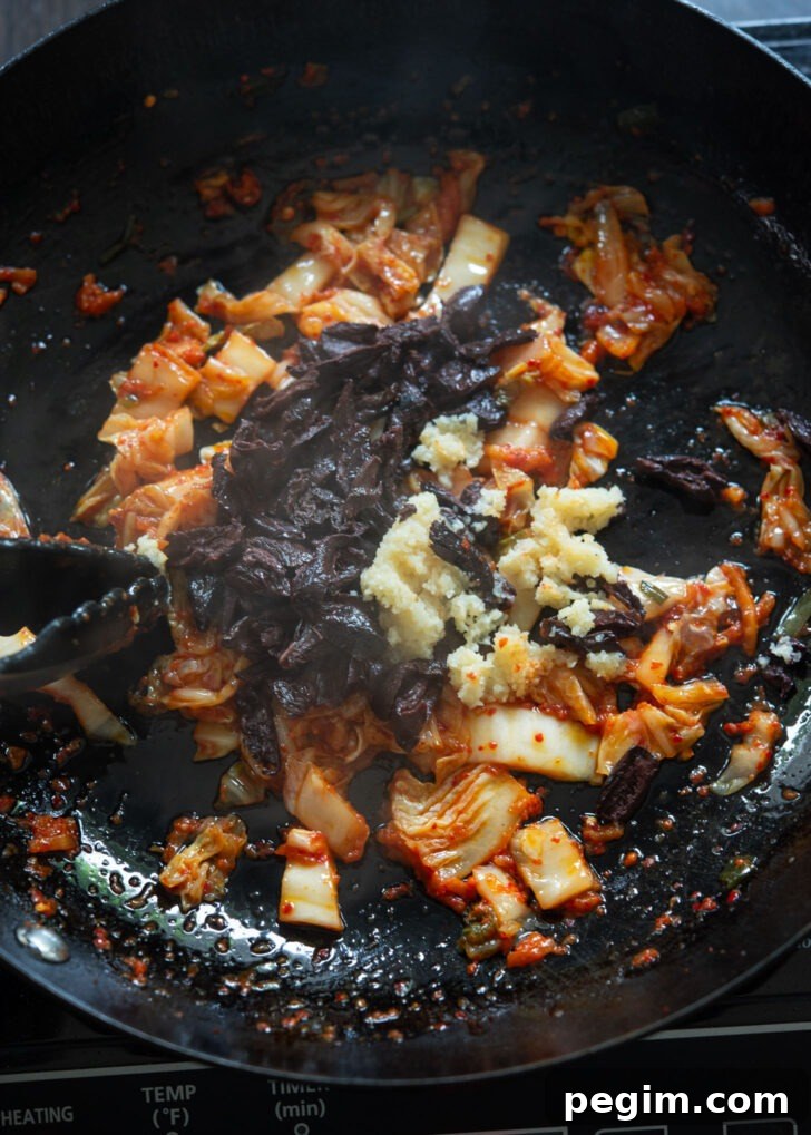 Olives and garlic are added to fried kimchi to make kimchi olive pasta. 