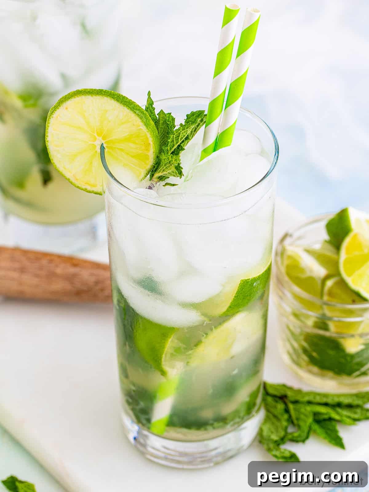 A classic mojito adorned with a green and white straw