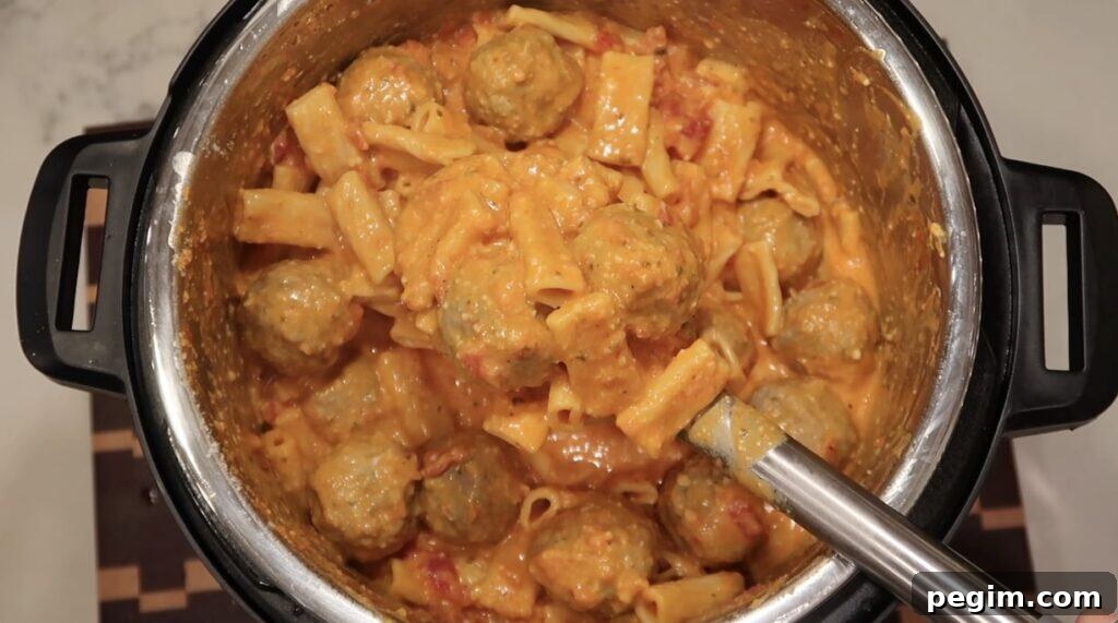 Mixed pasta tossed in sauce in pot