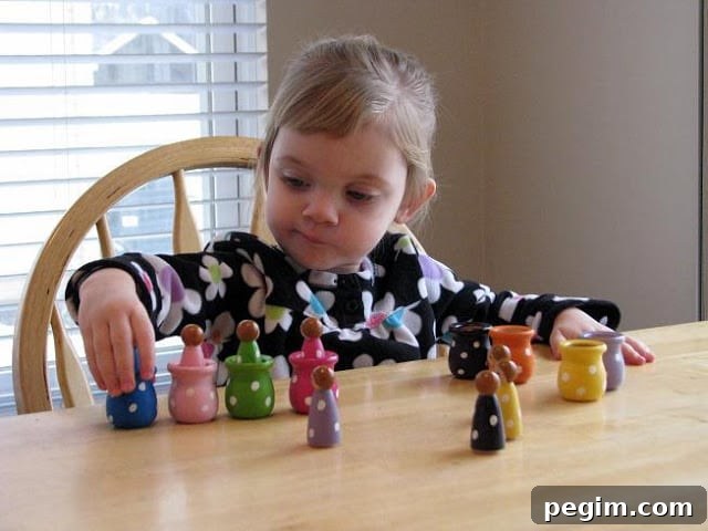 little girl playing with matching and sorting dolls on table