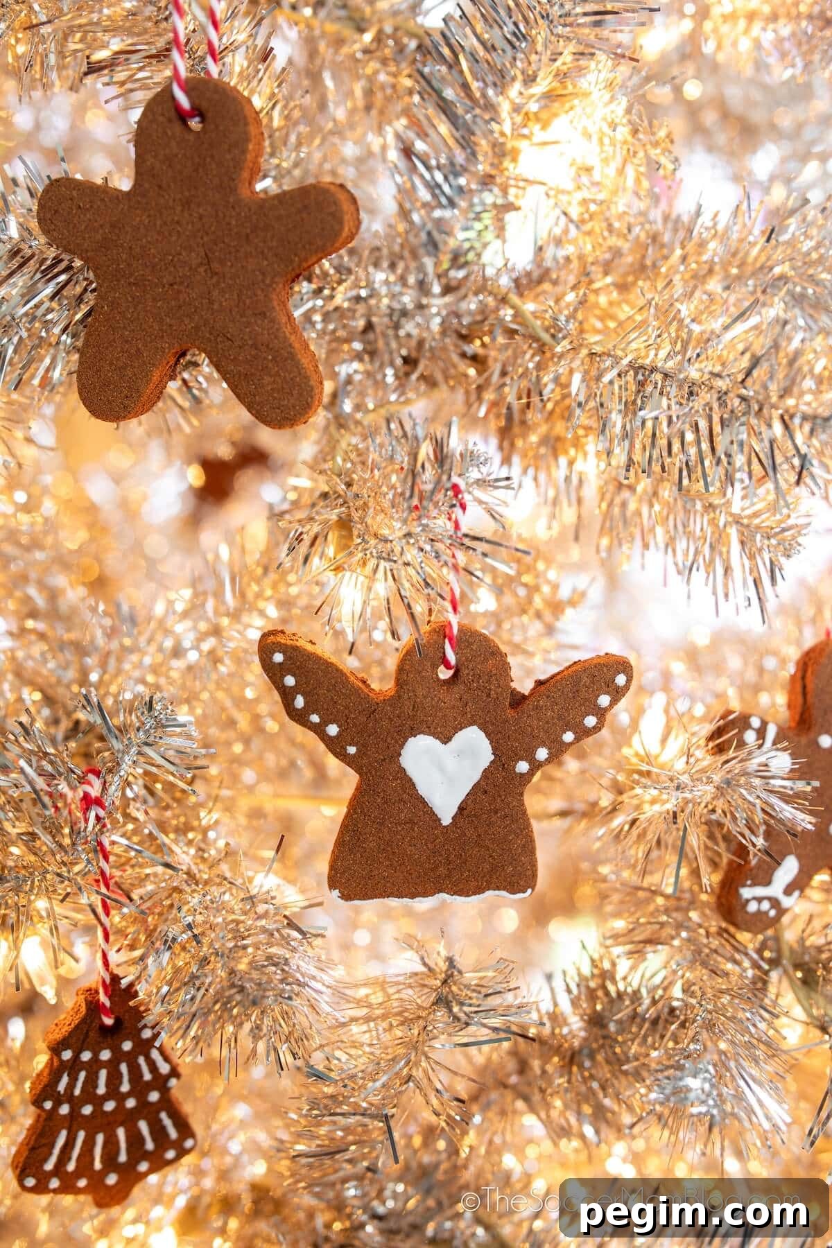 cinnamon ornaments hanging on a white Christmas tree.
