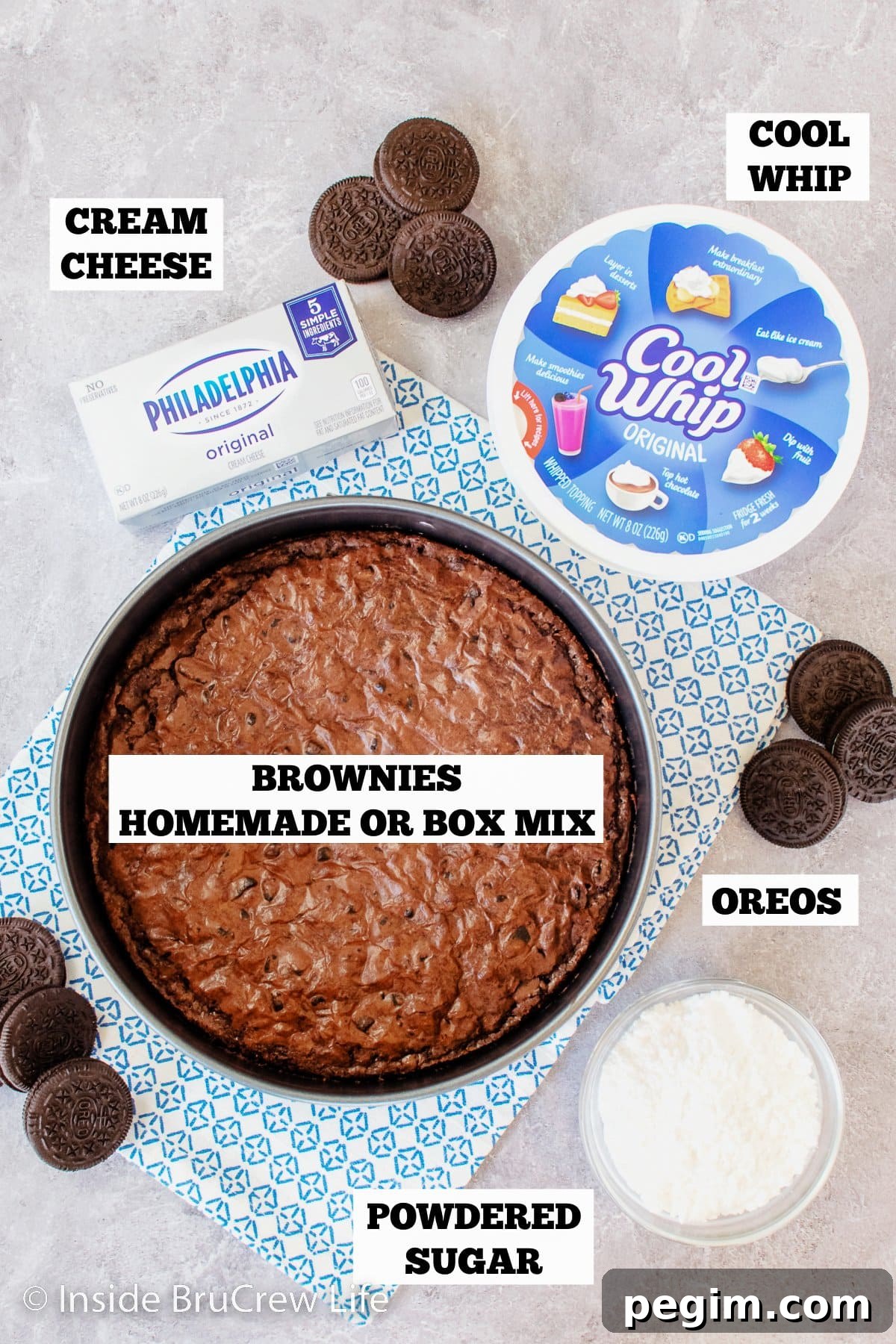 A gray board with bowls of ingredients for a brownie mousse cake.