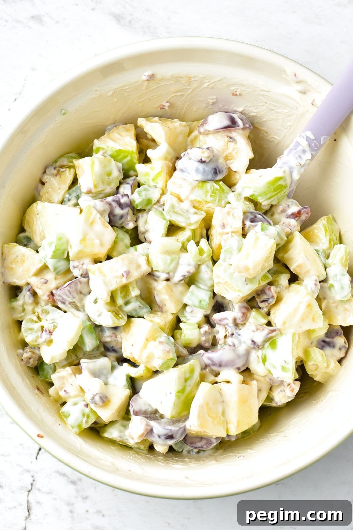 Mixing waldorf salad in bowl