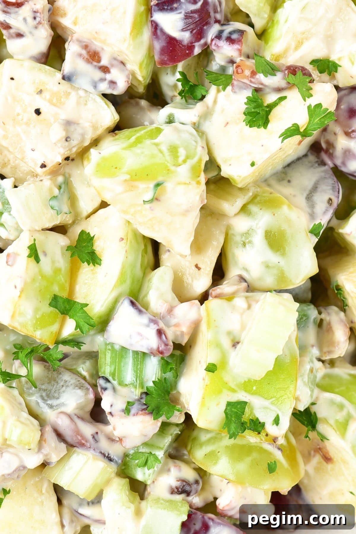 Up close view of waldorf salad topped with chopped parsley