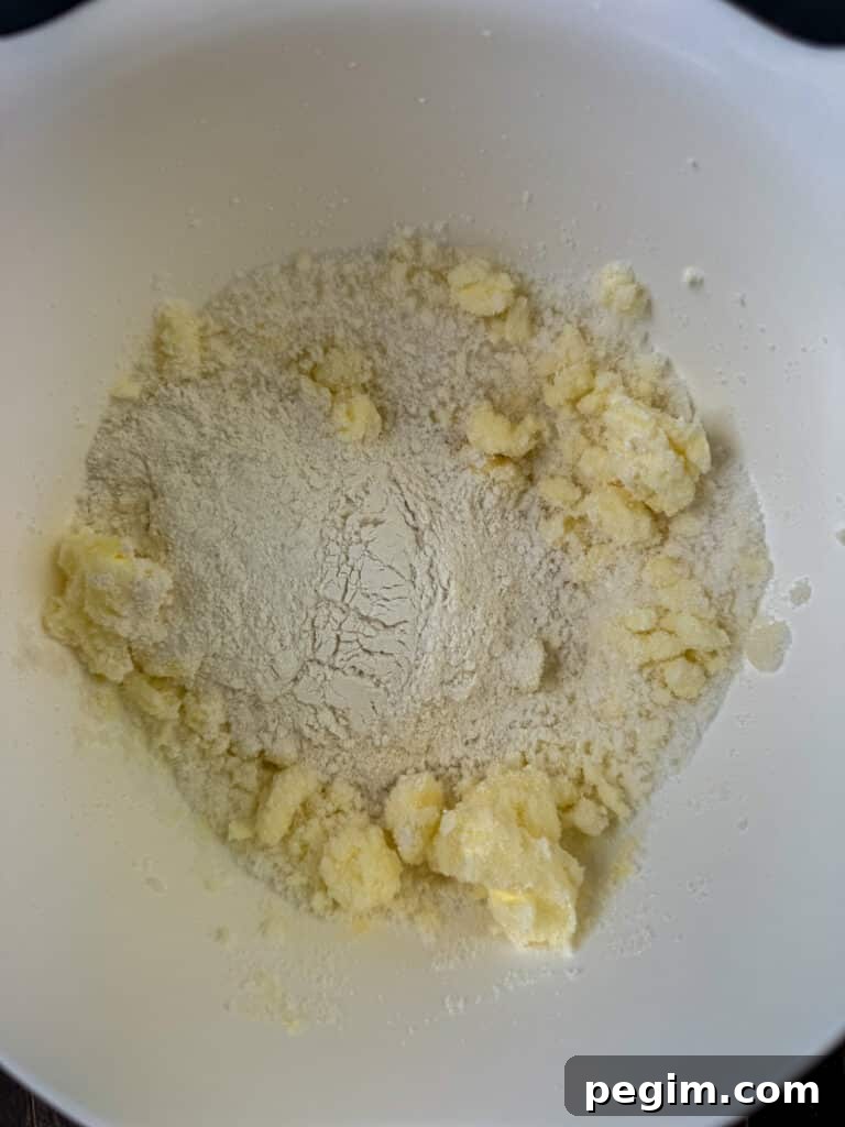 All-purpose flour poured into a bowl with sugar and butter.