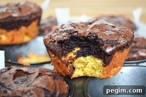Deep Dish Brookies with a bite out of one on top of a muffin pan. 