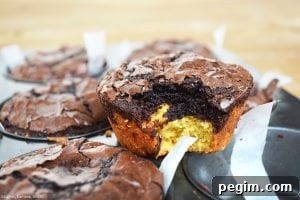 Deep Dish Brookies with a bite out of one on top of a muffin pan.