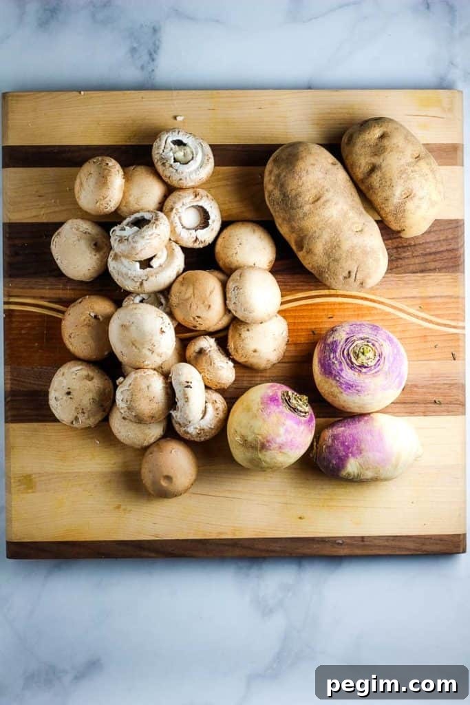 whole mushrooms, russet potatoes, and rutabagas on a wooden cutting board