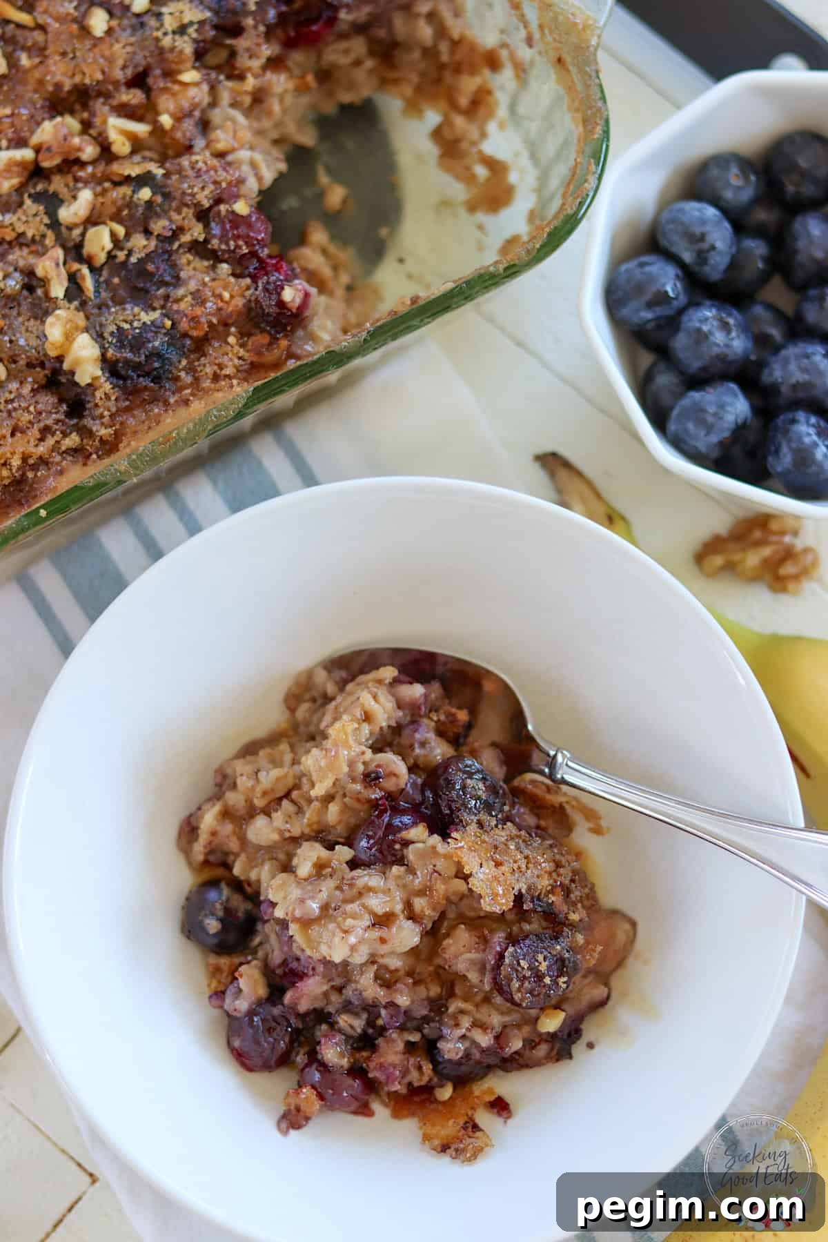 Blueberry baked oatmeal in a white bowl with a spoon.