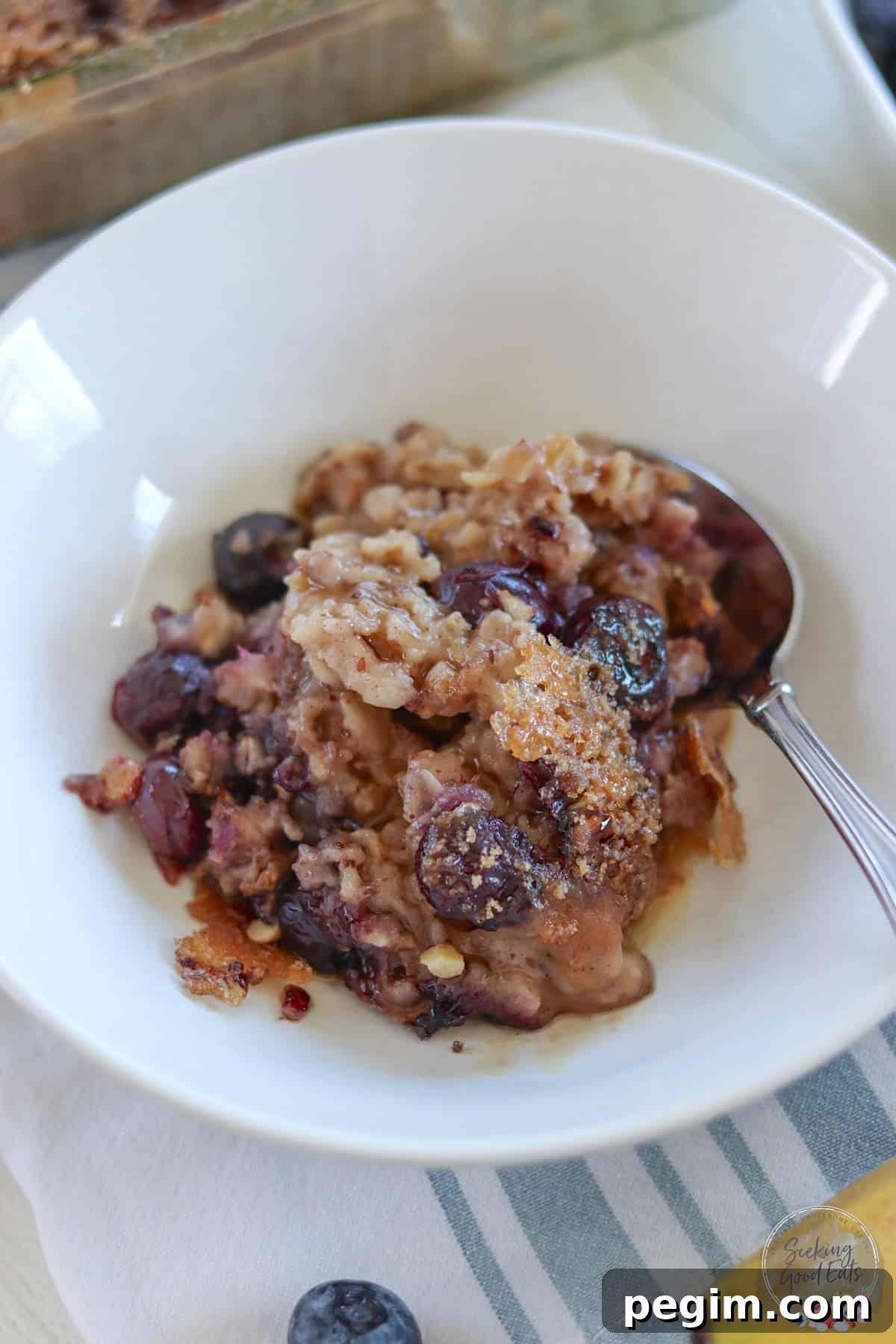 Healthy baked oatmeal drizzled with maple syrup in a white bowl.