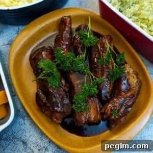A plate of sticky pork belly rashers, garnished with parsley and covered with maple glaze.
