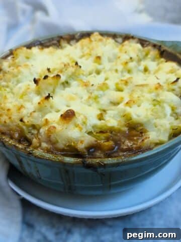 Colcannon-topped sausage bake in a green casserole dish.