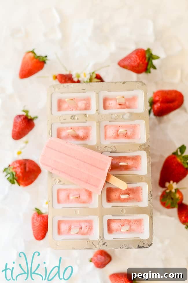 strawberries and cream popsicles on a white counter