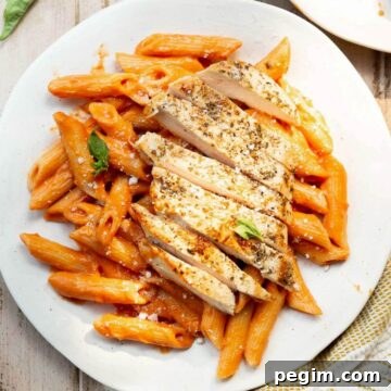Healthy henne alla vodka with chicken in a creamy blush-orange sauce made without heavy cream, topped with sliced chicken and fresh basil.