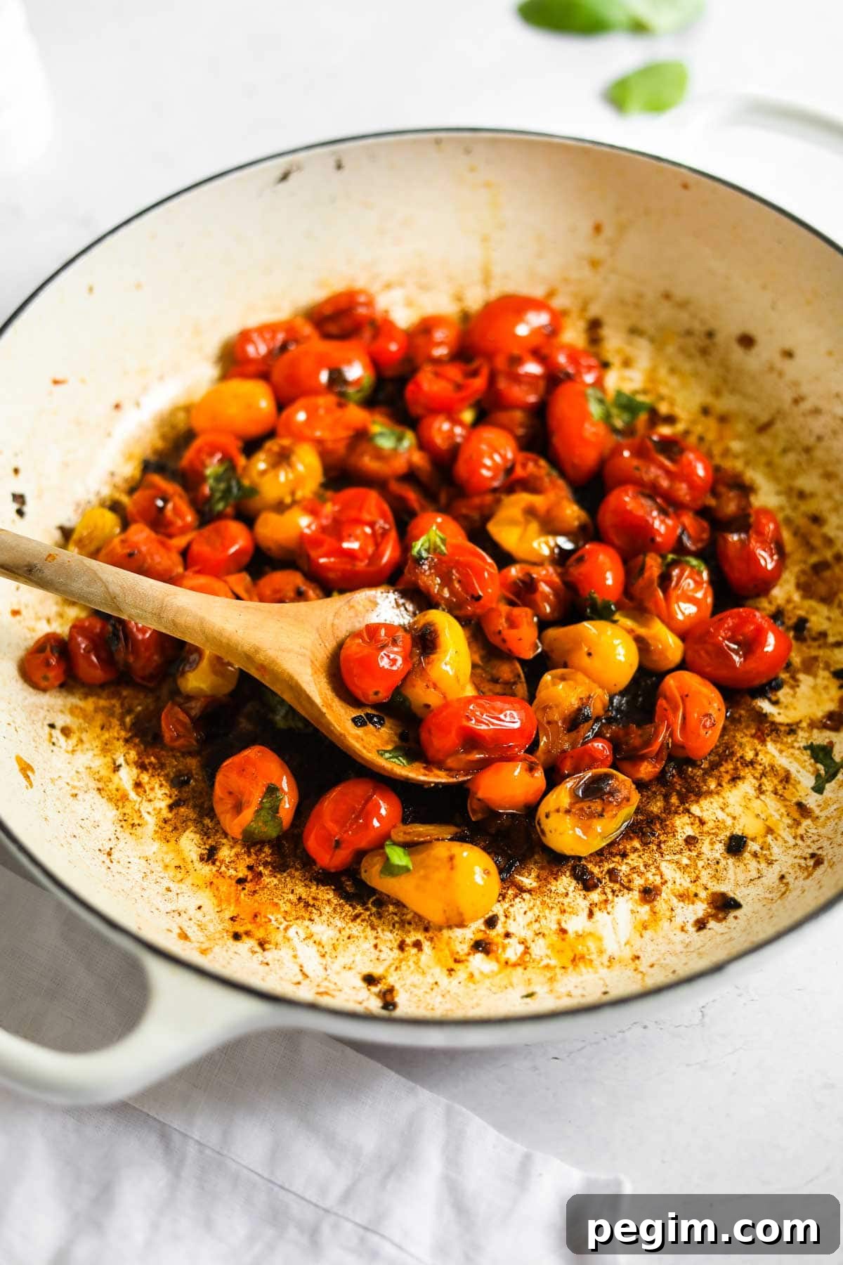 20 Delicious Side Dishes to Serve with Roasted Chicken 20 Blistered Cherry Tomatoes with olive wood spoon and Le Creuset White Braiser.