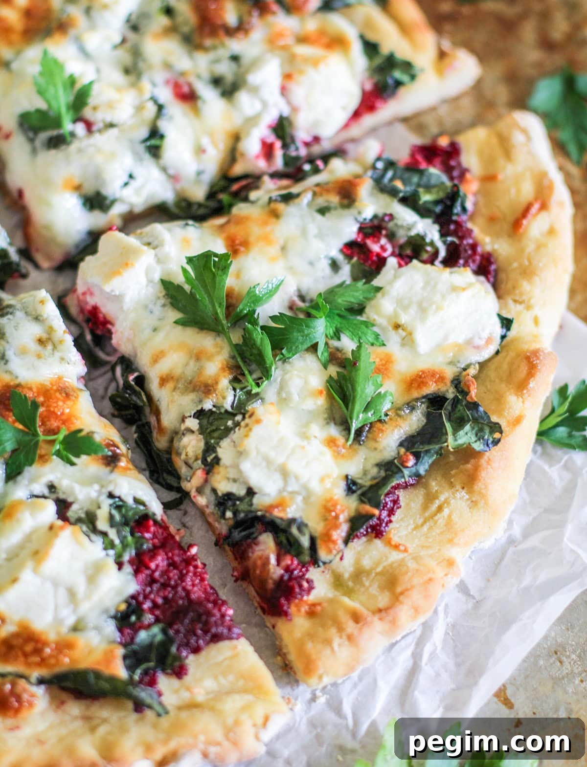 Four large slices of beet pesto pizza, fresh out of the oven.