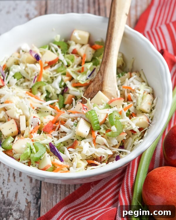 A large white serving bowl full of apple coleslaw.