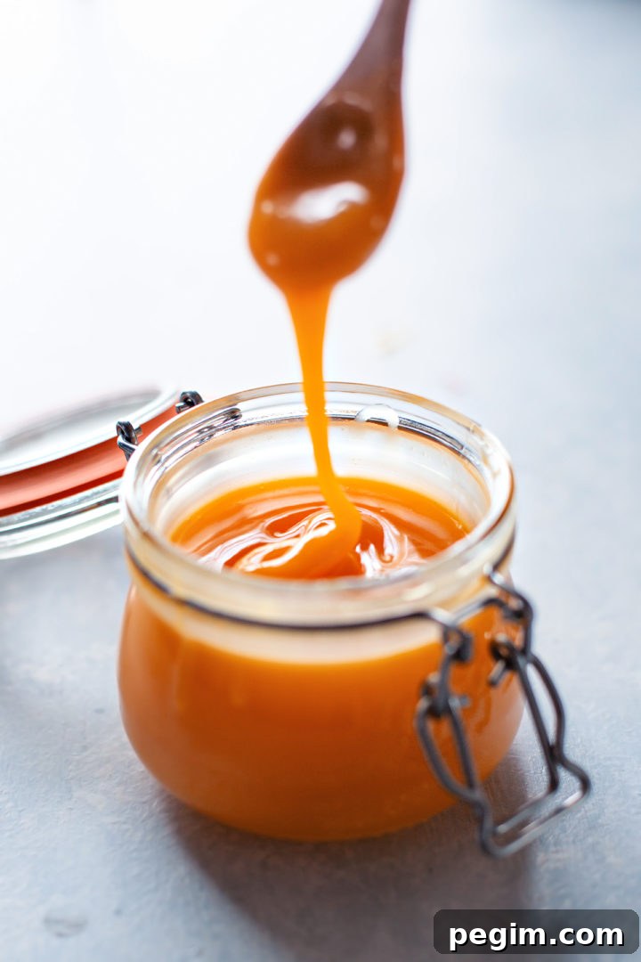 Grapefruit curd drizzling into a jar off of a spoon