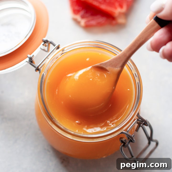photo of grapefruit curd in a jar with a spoon
