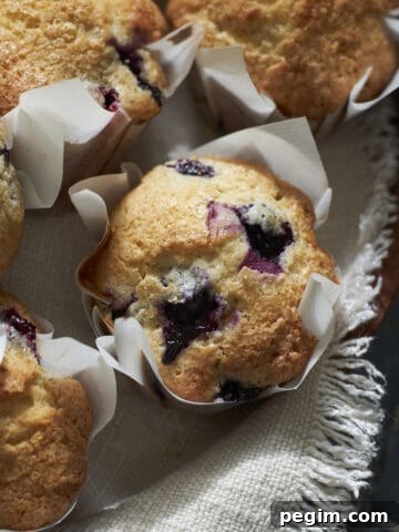 Sourdough Discard Blueberry Muffins on a wooden board.
