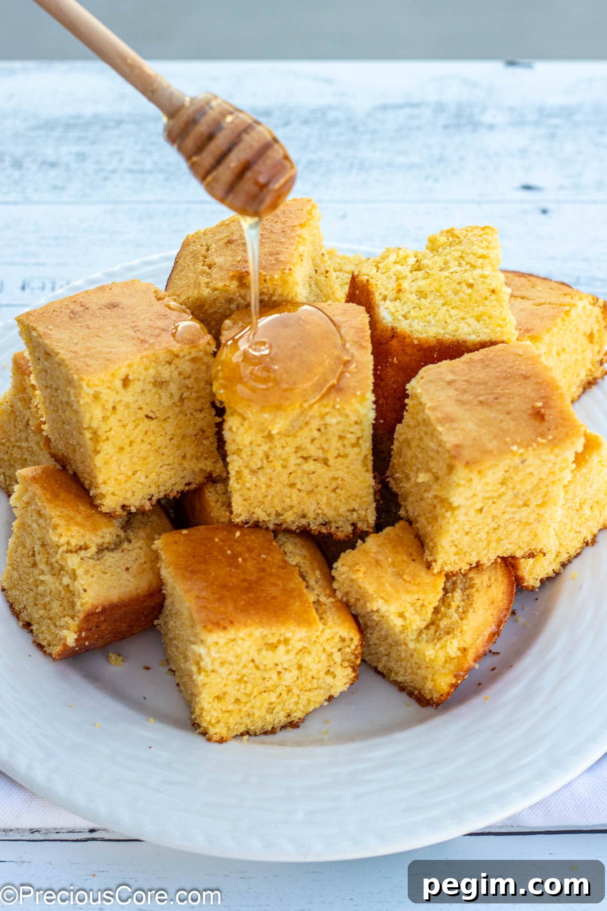 Honey wand drizzling honey on cornbread.
