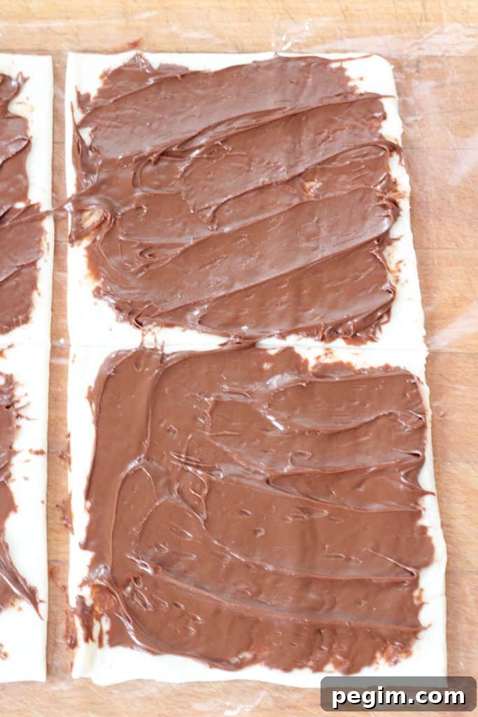 Cut puff pastry in squares and spread Nutella on it