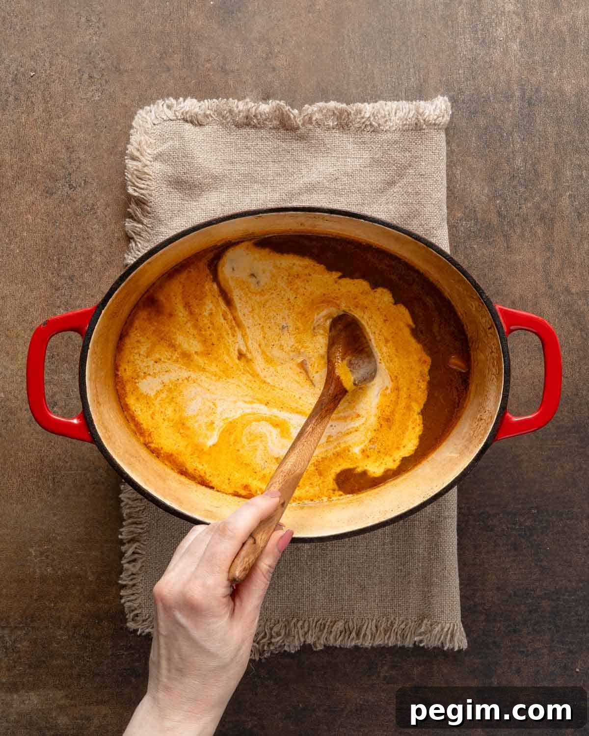 heavy cream being stirred into soup.